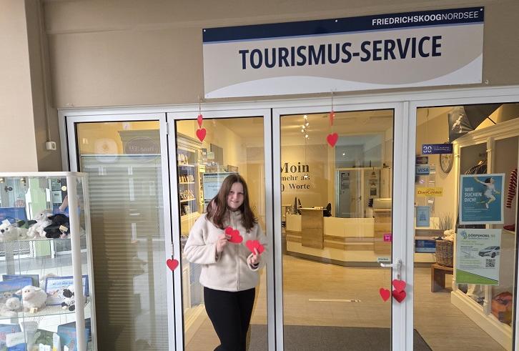 Tina, Angestellte des Tourismus-Service Friedrichskoog präsentiert vor dem Office die Herzen der Valentinsaktion, die im Trischendiek Park versteckt werden